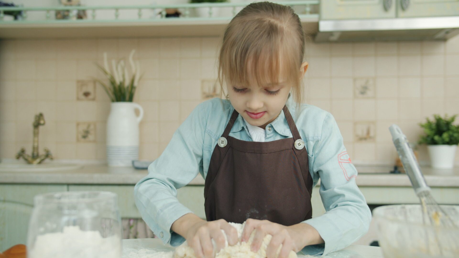 Young person baking in the kitchen with a parent present